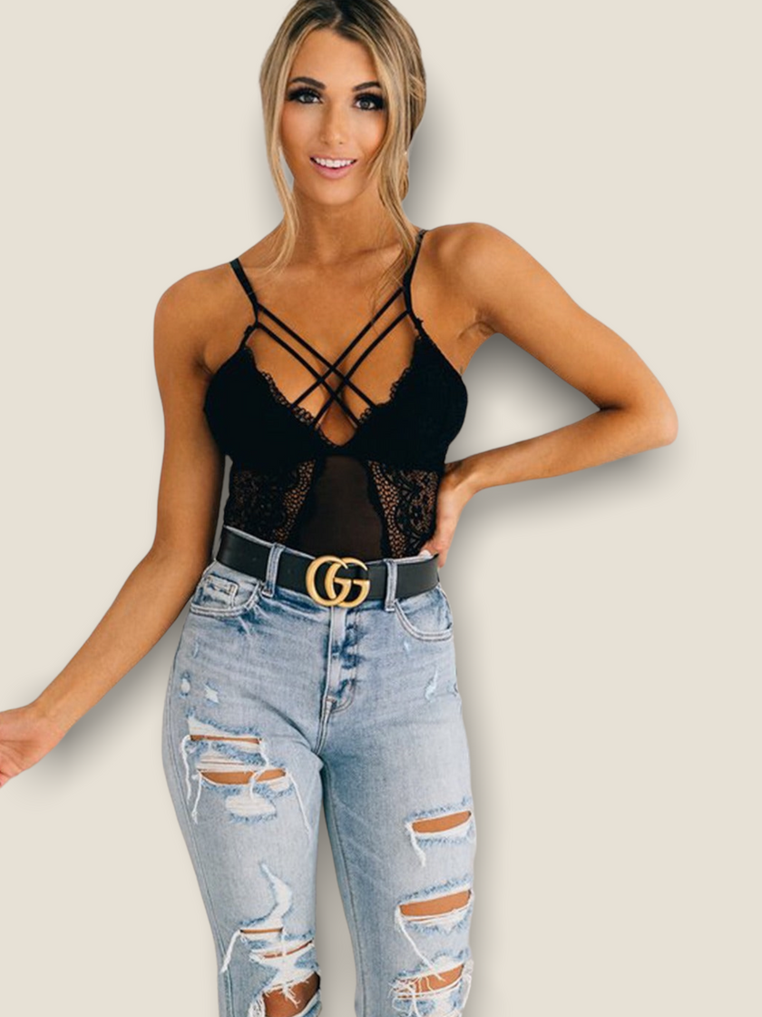 Stylish black lace bodysuit for women featuring crisscross straps and a sheer design, paired with ripped jeans