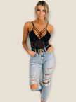 Stylish black lace bodysuit for women featuring crisscross straps, paired with ripped jeans