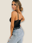 Stylish black lace bodysuit for women paired with trendy distressed jeans